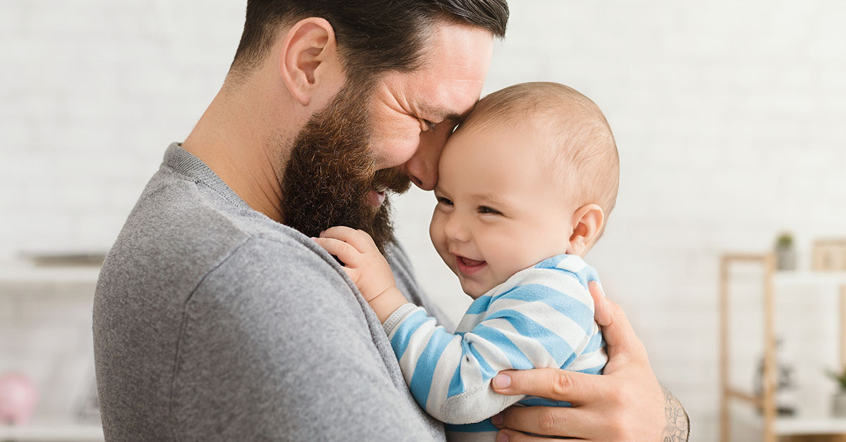 Cheerful father and son cuddling at home, enjoying time together; blog: How Men’s Health and Fertility are Linked